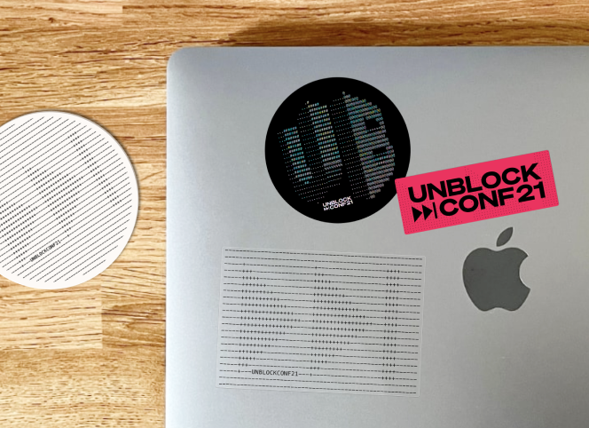 UnblockConf coaster and stickers on a laptop